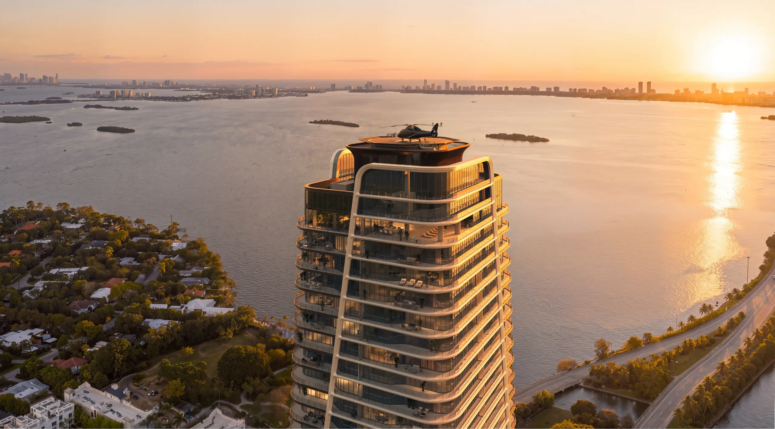The tower’s crown and helipad above the bay at sunset