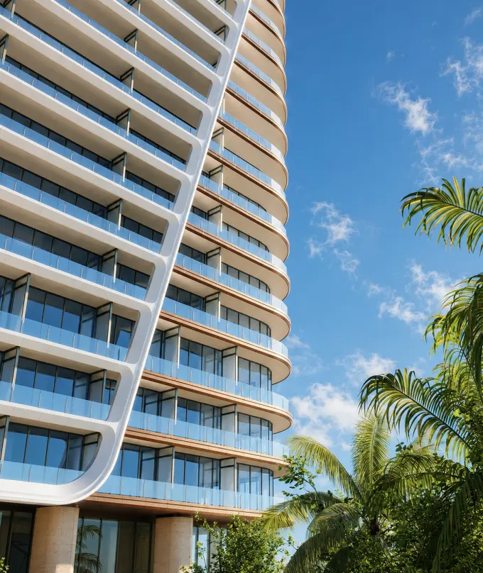The tower’s curved white balconies against a blue sky and palms
